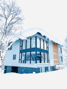um edifício coberto de neve na frente em Villa Yin Niseko em Niseko