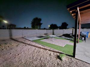 a concrete fence with a golf course in a yard at night at Chandler Charming Home in Chandler
