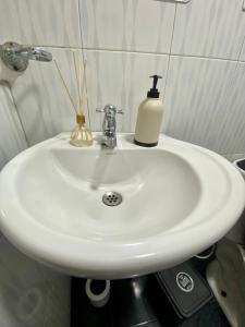 a white bathroom sink with a soap dispenser on it at Habitación Privada Cerca al Aeropuerto in Bogotá