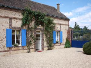 une maison en briques avec volets bleus et lierre dans l'établissement Gîte Le Boullay-Thierry, 3 pièces, 4 personnes - FR-1-581-6, à Le Boullay-Thierry