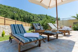 2 sedie a sdraio e un ombrellone su un patio di Villa Betty Dubrovnik a Gruda