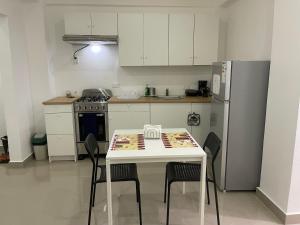 y cocina con mesa, sillas y nevera. en Plataview Apartahotel apt 4C, en Monte Plata