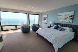 1 dormitorio con cama grande y ventana grande en Heathcliff. Stunning ocean views!, en Boat Harbour