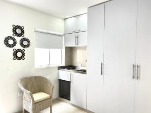 una cocina con armarios blancos y una silla en Aparta estudios nuevos Mubarak, en Barranquilla