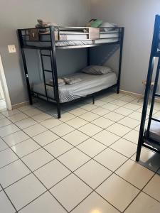 a black bunk bed in a room with a tiled floor at Beds & Sheets Little Havana in Miami