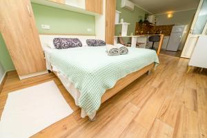 ein Schlafzimmer mit einem Bett mit einer grünen und weißen karierten Decke in der Unterkunft Apartments with a parking space Mali Losinj (Losinj) - 16555 in Mali Lošinj