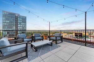 a patio with furniture and a grill on a balcony at Downtownkingrooftopfitnesstop Flr City View in Oak Park