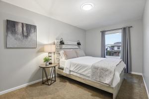 a white bedroom with a bed and a window at Comfort & Convenience 3bd, 15 Near Hwy & Mall in Bolingbrook