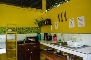 a kitchen with yellow walls and a counter with a sink at The Jungle Container in Quepos