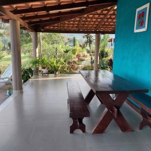 una mesa de picnic de madera y un banco en un patio en Casa Ambrósio Capitólio en Capitólio