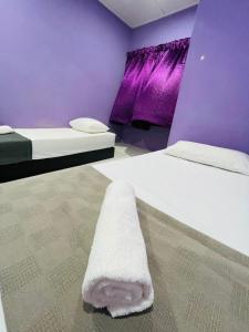 two beds in a purple room with a towel on the floor at FREE Wi-fi 100mbps I Emerald Cove Rawang in Rawang