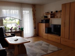 een woonkamer met een tafel en een televisie bij Apartment in Bissendorf near Osnabrück in Bissendorf