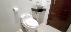 a white bathroom with a toilet and a sink at Suite Posada Express with Free Airport Shuttle in Santa Cruz de la Sierra