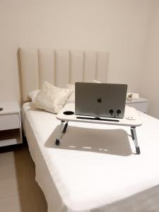 a laptop computer sitting on top of a bed at Suite Posada Express with Free Airport Shuttle in Santa Cruz de la Sierra