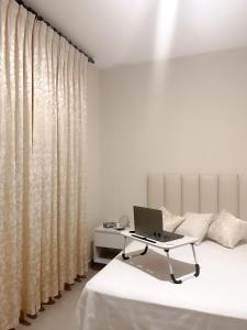 a bedroom with a laptop sitting on a bed at Suite Posada Express with Free Airport Shuttle in Santa Cruz de la Sierra