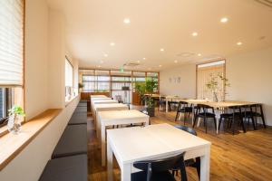 a restaurant with tables and chairs and windows at Yawarano-yu MARUYA For women only in Ise