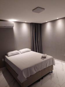 ein Schlafzimmer mit einem großen Bett mit weißer Bettwäsche in der Unterkunft Apartamento Brisa da Ilha in Cayru