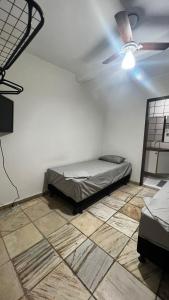 um quarto com uma cama e uma ventoinha de tecto em Sossai Hostel em Vitória