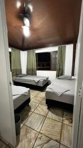 Sossai Hostel في فيتوريا: غرفة بثلاث اسرة وسقف