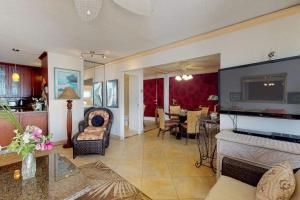 a living room with a tv and a couch and a table at Island Sands Resort Condominiums in Wailuku