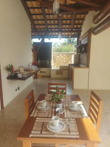 a dining room with a table and chairs and a kitchen at Casarão Caborê in Paraty