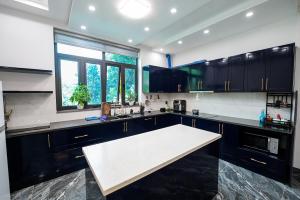 a kitchen with black cabinets and a white counter top at Dream Hill Villa - Biệt thự trên đồi full tiện ích dịch vụ, ăn uống, tổ chức event in Hanoi