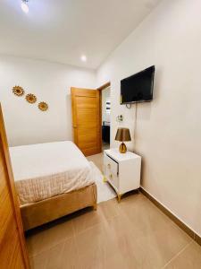 a bedroom with a bed and a flat screen tv at Modern Oasis By The Waves. in Santa Cruz de Barahona