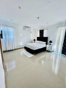a bedroom with a bed in a white room at Modern Oasis By The Waves. in Santa Cruz de Barahona