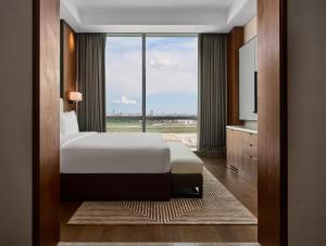 a hotel room with a bed and a large window at Crowne Plaza Phnom Penh by IHG in Phnom Penh