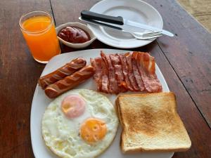 a plate of breakfast food with eggs bacon and toast at Ao Thong beach Resort in Khao Lak