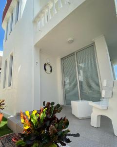 een wit huis met een bank en een raam bij Cabaña Arrecife 07 in Coveñas