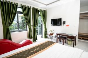 a bedroom with a bed and a desk and a window at LUCKY HOTEL LIEN PHUONG in Ho Chi Minh City