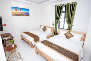 a hotel room with two beds and a table at LUCKY HOTEL LIEN PHUONG in Ho Chi Minh City