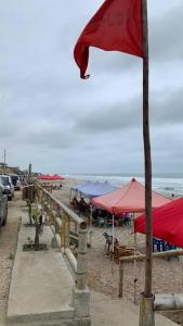 eine rote Flagge am Strand mit Sonnenschirmen in der Unterkunft Suite privada para 5 personas - #5 Playa Engabao in Playas