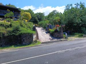 a road next to a building with flowers on it at Tehuarupe Surf Studios in Haapiti