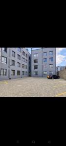 a large building with a car parked in a parking lot at Mupa's Luxury Condo II in Nyahururu