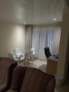 a hotel room with a bed and a table and chairs at Purple Olive Guest House in Pretoria