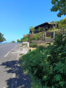 an empty road with a house in the background at Tehuarupe Surf Studios in Haapiti