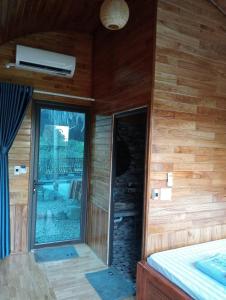 a room with a bed and a glass door at La Bằng Homestay in Lá Cam