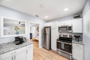 a kitchen with white cabinets and stainless steel appliances at Stylish Urban Nest, close to parks and restaurants in Savannah