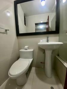 uma casa de banho com um WC, um lavatório e um espelho. em Hotel Plaza Teatro em Chiclayo