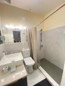 uma casa de banho com um lavatório, um WC e um chuveiro em Appartement Luxe idéalement situé à Dakar em Dakar