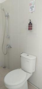 een witte badkamer met een toilet en een douche bij Homestay Titiknol Yogya in Yogyakarta