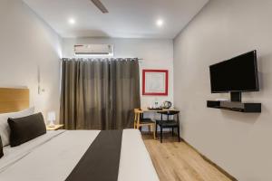een hotelkamer met een bed en een televisie bij Super Townhouse 176 Rajdhani Residency in Surūrnagar