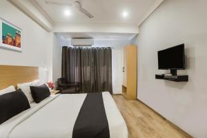 a bedroom with a bed and a flat screen tv at Super Townhouse 176 Rajdhani Residency in Surūrnagar