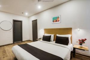 een slaapkamer met een groot bed in een kamer bij Super Townhouse 176 Rajdhani Residency in Surūrnagar
