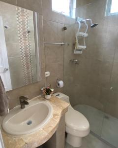 een badkamer met een wastafel, een toilet en een douche bij Cabaña Arrecife 07 in Coveñas