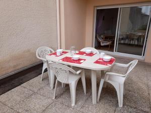 een witte tafel en stoelen met een rode tafelkleed bij Appartement Arcachon, 2 pièces, 4 personnes - FR-1-319-506 in Arcachon