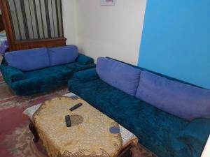 - un salon avec un canapé bleu et une table dans l'établissement Cozy private room in downtown kasr nile, au Caire