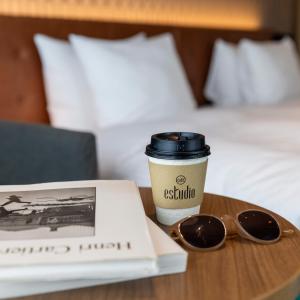 una tazza di caffè e un libro e occhiali da sole su un tavolo di Kobe Hotel Juraku a Kobe